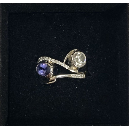 53 - A STUNNING HANDMADE PLATINUM DIAMOND AND TANZANITE RING, with beautiful round brilliant cut diamond ... 