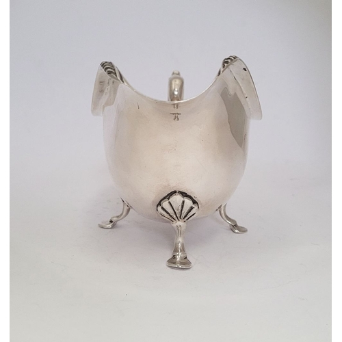 9 - AN IRISH CORK SILVER SAUCE BOAT, with gadrooned edge, a scroll shaped handle resting on a tripod leg... 