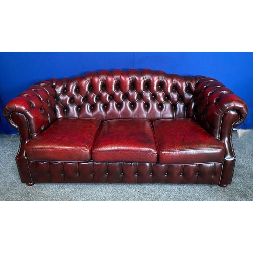 117 - AN EXCELLENT OXBLOOD LEATHER THREE-SEATER CHESTERFIELD COUCH, with arched back and scroll armrests, ... 