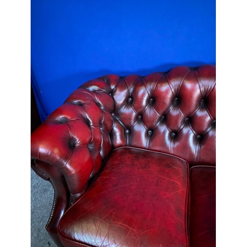 117 - AN EXCELLENT OXBLOOD LEATHER THREE-SEATER CHESTERFIELD COUCH, with arched back and scroll armrests, ... 