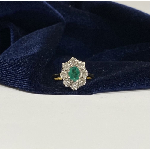 12 - AN 18CT YELLOW GOLD EMERALD & DIAMOND CLUSTER RING, with central oval cut vibrant emerald in claw se... 