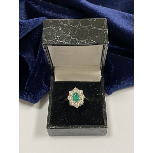 12 - AN 18CT YELLOW GOLD EMERALD & DIAMOND CLUSTER RING, with central oval cut vibrant emerald in claw se... 