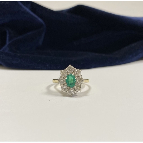 12 - AN 18CT YELLOW GOLD EMERALD & DIAMOND CLUSTER RING, with central oval cut vibrant emerald in claw se... 