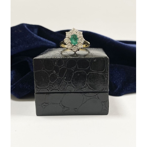 12 - AN 18CT YELLOW GOLD EMERALD & DIAMOND CLUSTER RING, with central oval cut vibrant emerald in claw se... 