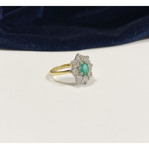 12 - AN 18CT YELLOW GOLD EMERALD & DIAMOND CLUSTER RING, with central oval cut vibrant emerald in claw se... 