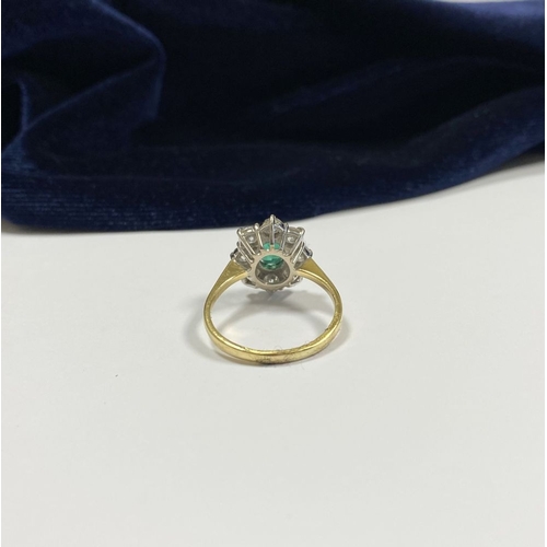 12 - AN 18CT YELLOW GOLD EMERALD & DIAMOND CLUSTER RING, with central oval cut vibrant emerald in claw se... 