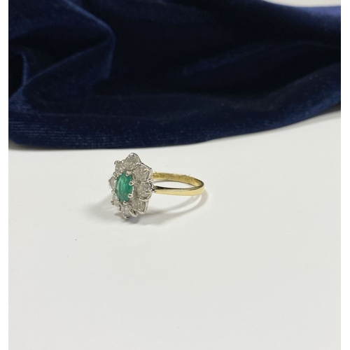 12 - AN 18CT YELLOW GOLD EMERALD & DIAMOND CLUSTER RING, with central oval cut vibrant emerald in claw se... 