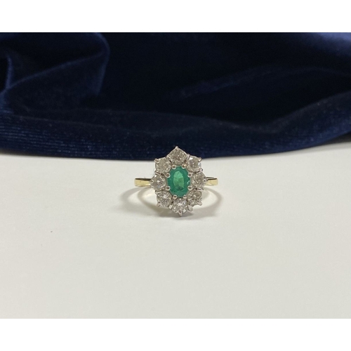 12 - AN 18CT YELLOW GOLD EMERALD & DIAMOND CLUSTER RING, with central oval cut vibrant emerald in claw se... 