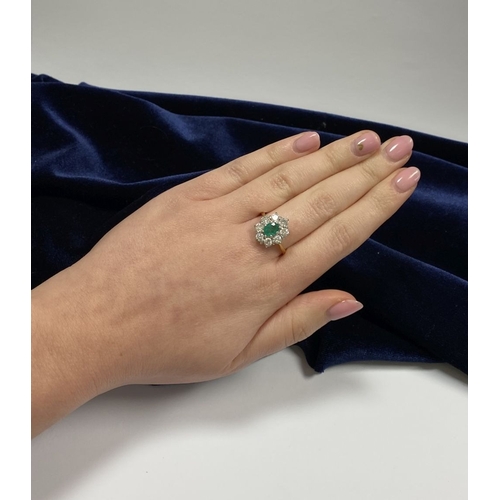 12 - AN 18CT YELLOW GOLD EMERALD & DIAMOND CLUSTER RING, with central oval cut vibrant emerald in claw se... 