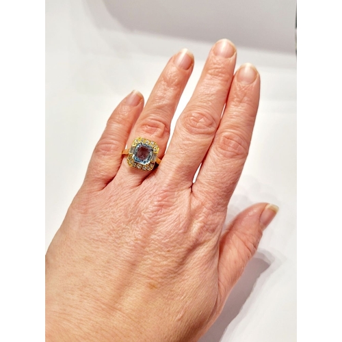 120 - A PRETTY 18CT YELLOW GOLD AQUAMARINE & DIAMOND CLUSTER RING, with a large central pale blue aquamari... 