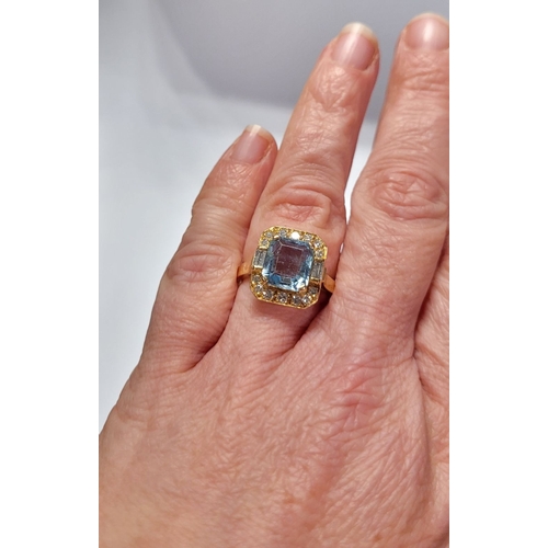 120 - A PRETTY 18CT YELLOW GOLD AQUAMARINE & DIAMOND CLUSTER RING, with a large central pale blue aquamari... 