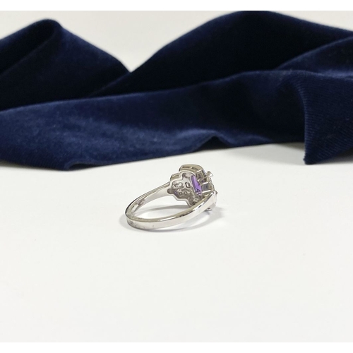 132 - AN 18CT WHITE GOLD AMETHYST & DIAMOND RING, the central amethyst is set in a four prong claw setting... 