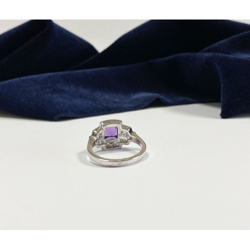 132 - AN 18CT WHITE GOLD AMETHYST & DIAMOND RING, the central amethyst is set in a four prong claw setting... 