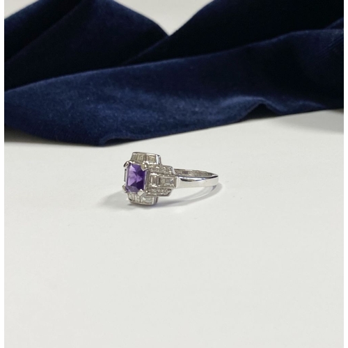 132 - AN 18CT WHITE GOLD AMETHYST & DIAMOND RING, the central amethyst is set in a four prong claw setting... 