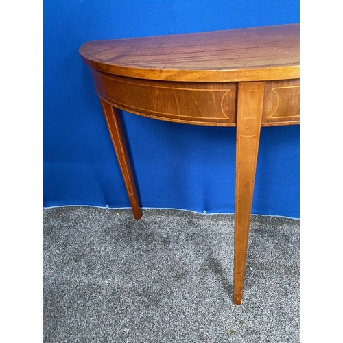 136 - A GOOD QUALITY MAHOGANY INLAID HALF MOON HALL/SIDE TABLE, with inlay to top, frieze and tapered legs... 