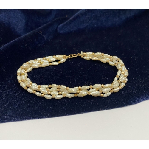 147 - A PRETTY 9CT GOLD FOUR STRAND PEARL BRACELET, each strand featuring freshwater baroque shaped pearls... 