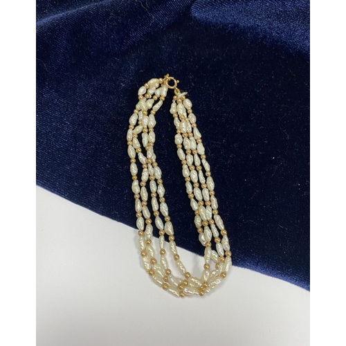 147 - A PRETTY 9CT GOLD FOUR STRAND PEARL BRACELET, each strand featuring freshwater baroque shaped pearls... 