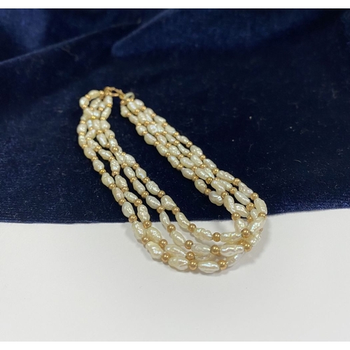 147 - A PRETTY 9CT GOLD FOUR STRAND PEARL BRACELET, each strand featuring freshwater baroque shaped pearls... 