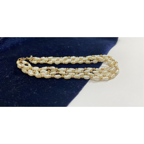 147 - A PRETTY 9CT GOLD FOUR STRAND PEARL BRACELET, each strand featuring freshwater baroque shaped pearls... 