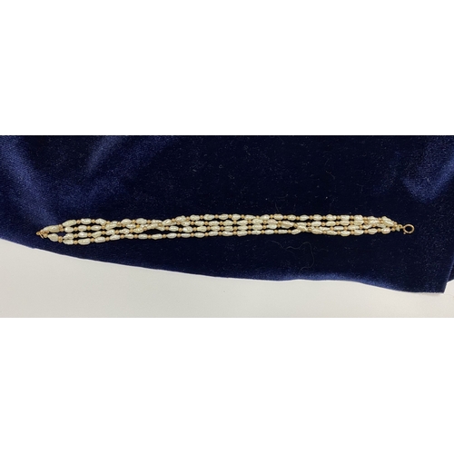 147 - A PRETTY 9CT GOLD FOUR STRAND PEARL BRACELET, each strand featuring freshwater baroque shaped pearls... 