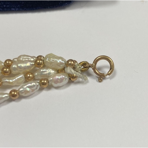 147 - A PRETTY 9CT GOLD FOUR STRAND PEARL BRACELET, each strand featuring freshwater baroque shaped pearls... 