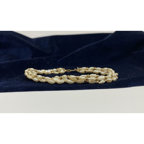 147 - A PRETTY 9CT GOLD FOUR STRAND PEARL BRACELET, each strand featuring freshwater baroque shaped pearls... 