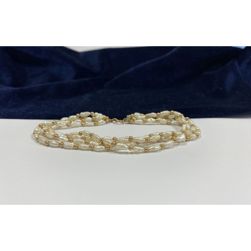 147 - A PRETTY 9CT GOLD FOUR STRAND PEARL BRACELET, each strand featuring freshwater baroque shaped pearls... 