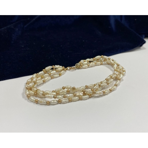 147 - A PRETTY 9CT GOLD FOUR STRAND PEARL BRACELET, each strand featuring freshwater baroque shaped pearls... 