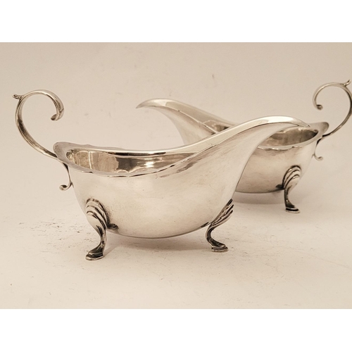 154 - A FINE PAIR OF SILVER SAUCE BOATS, with scalloped rim and open scroll handles, each sitting proudly ... 