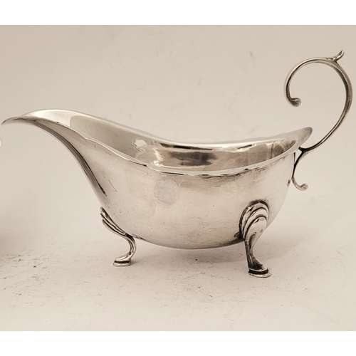 154 - A FINE PAIR OF SILVER SAUCE BOATS, with scalloped rim and open scroll handles, each sitting proudly ... 