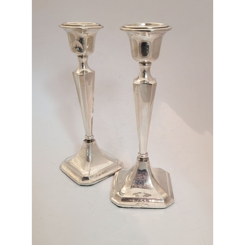 159 - TWO EARLY 20TH CENTURY ART DECO SILVER TAPERED CANDLESTICKS, with octagonal shaped base and column b... 