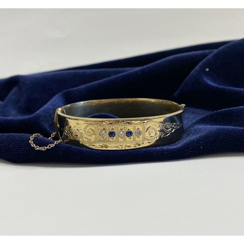 164 - A BEAUTIFUL 9CT GOLD PLATED GEMSET BANGLE BRACELET, with two round cut blue gemstones and three roun... 