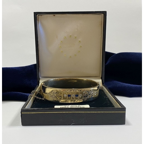 164 - A BEAUTIFUL 9CT GOLD PLATED GEMSET BANGLE BRACELET, with two round cut blue gemstones and three roun... 