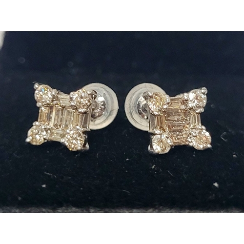 17 - A STRIKING PAIR OF 18CT WHITE GOLD DIAMOND STUD EARRINGS, with baguette cut diamonds to centre surro... 