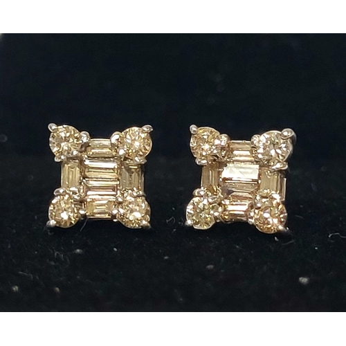 17 - A STRIKING PAIR OF 18CT WHITE GOLD DIAMOND STUD EARRINGS, with baguette cut diamonds to centre surro... 