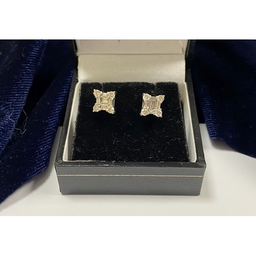 17 - A STRIKING PAIR OF 18CT WHITE GOLD DIAMOND STUD EARRINGS, with baguette cut diamonds to centre surro... 