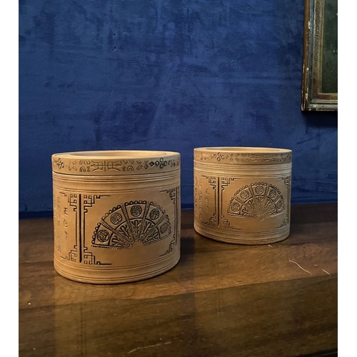 199 - A PAIR OF CHINESE RED CLAY CANNISTERS, cylindrical form, the sides decorated with panels depicting f... 