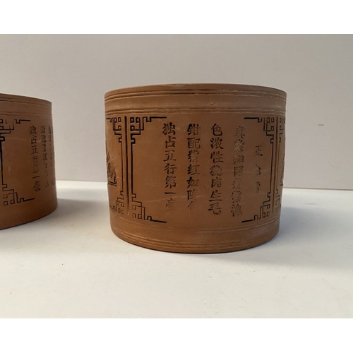 199 - A PAIR OF CHINESE RED CLAY CANNISTERS, cylindrical form, the sides decorated with panels depicting f... 