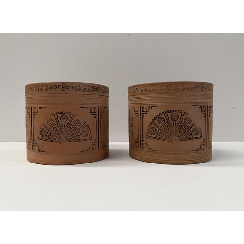 199 - A PAIR OF CHINESE RED CLAY CANNISTERS, cylindrical form, the sides decorated with panels depicting f... 