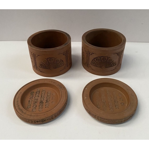 199 - A PAIR OF CHINESE RED CLAY CANNISTERS, cylindrical form, the sides decorated with panels depicting f... 