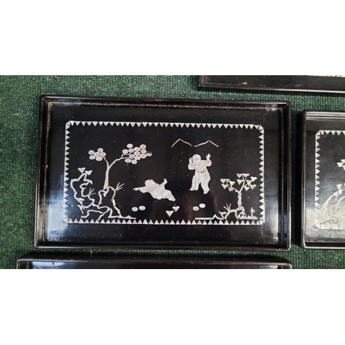 207 - A SET OF FIVE VINTAGE LACQUER & MOTHER OF PEARL INLAID TRAYS of graduating sizes, each depicting fig... 