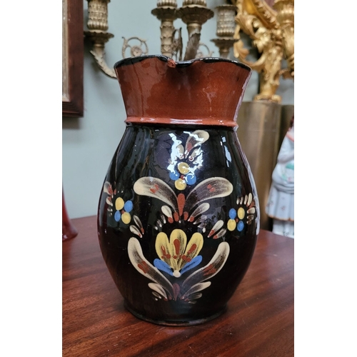 209 - TWO EARTHENWARE HAND PAINTED & GLAZED JUGS, (i) A lovely brown earthenware jug, with floral decorati... 