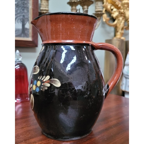 209 - TWO EARTHENWARE HAND PAINTED & GLAZED JUGS, (i) A lovely brown earthenware jug, with floral decorati... 