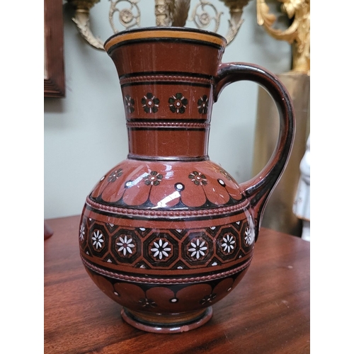 209 - TWO EARTHENWARE HAND PAINTED & GLAZED JUGS, (i) A lovely brown earthenware jug, with floral decorati... 