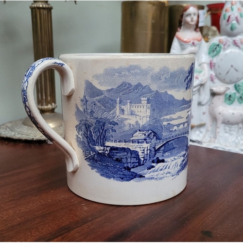 210 - A LARGE ANTIQUE BLUE & WHITE MUG, decorated with landscape scenes to the outside, and a band of flor... 