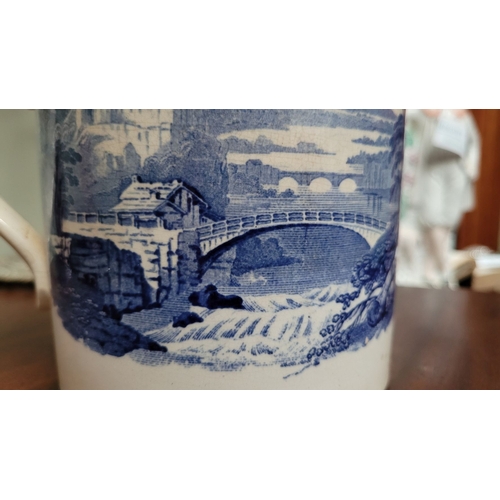 210 - A LARGE ANTIQUE BLUE & WHITE MUG, decorated with landscape scenes to the outside, and a band of flor... 