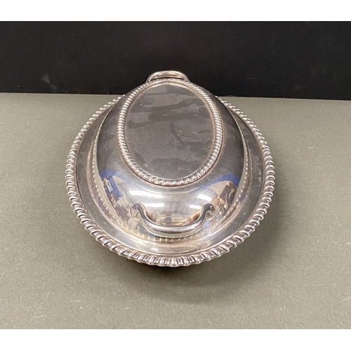 246 - A SILVERPLATE LOT TO INCLUDE (i) an oval covered tray, with two handles and gadrooned design to cove... 