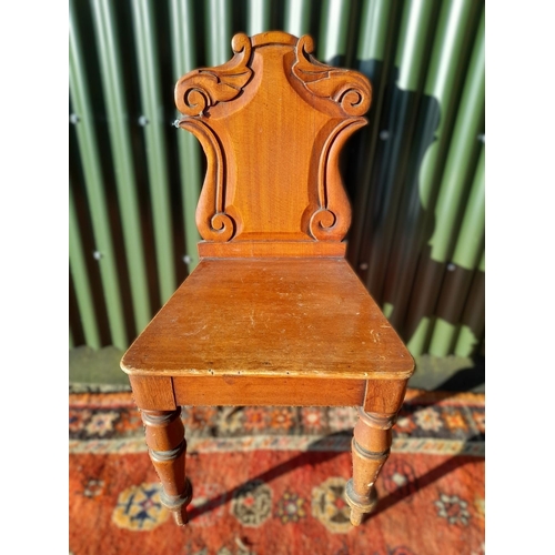 250 - A GOOD MAHOGANY CARVED HALL CHAIR, with carved shield back, raised on turned leg. In overall good co... 