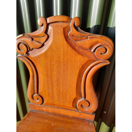 250 - A GOOD MAHOGANY CARVED HALL CHAIR, with carved shield back, raised on turned leg. In overall good co... 