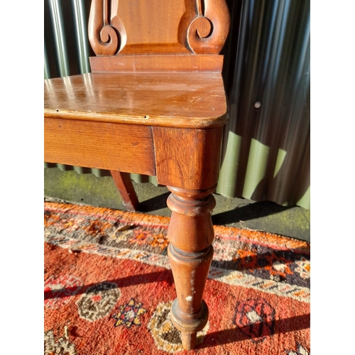 250 - A GOOD MAHOGANY CARVED HALL CHAIR, with carved shield back, raised on turned leg. In overall good co... 